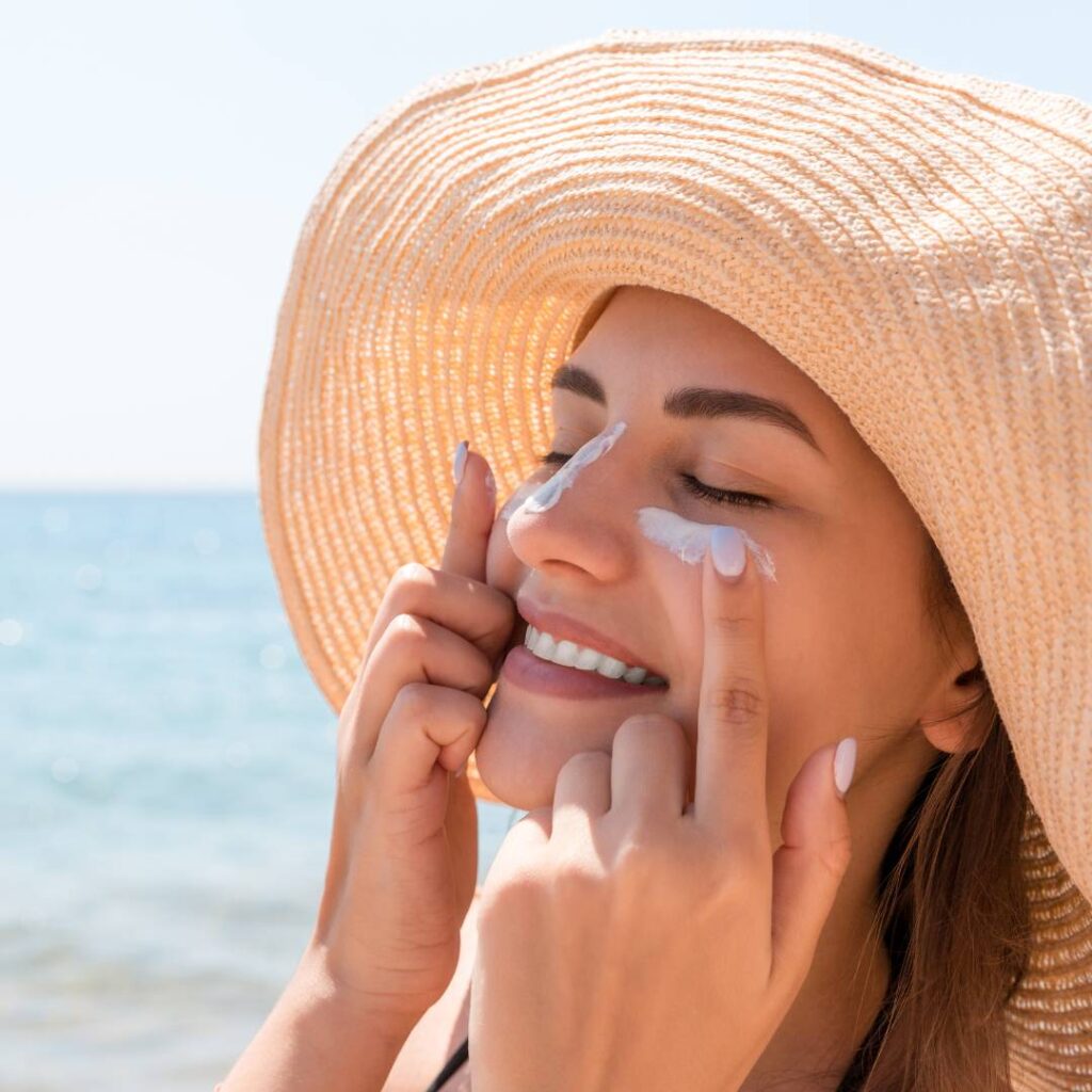 Woman protecting her skin against fine lines and wrinkles by using sun protection